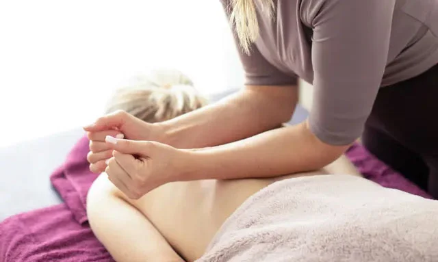Therapist massaging a client's shoulders and upper back at Ekantik Studio